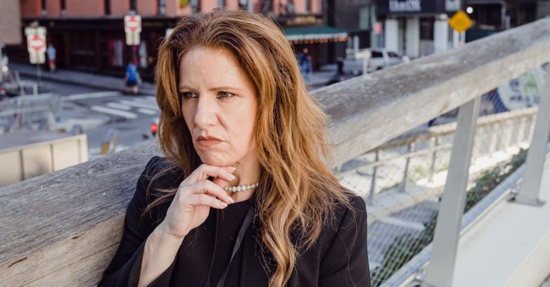 Considerations - Businesswoman Leaning against Railing in a City and Calculating Business Risk