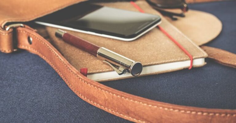 Content - Smartphone Displaying Black Screen on Notebook Beside Pen and Sunglasses